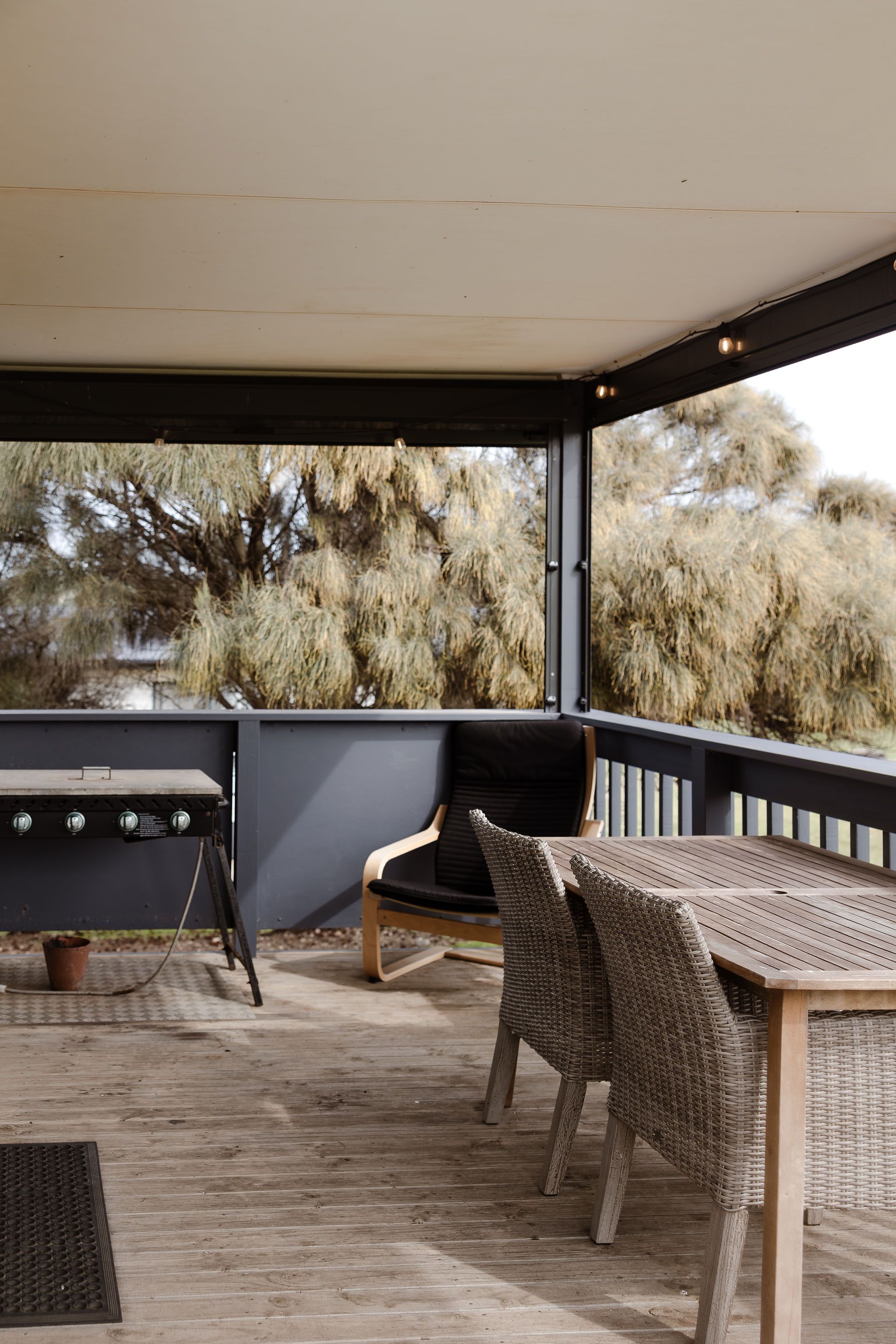 A cottage exterior with a wide verandah over the paddock to the sea